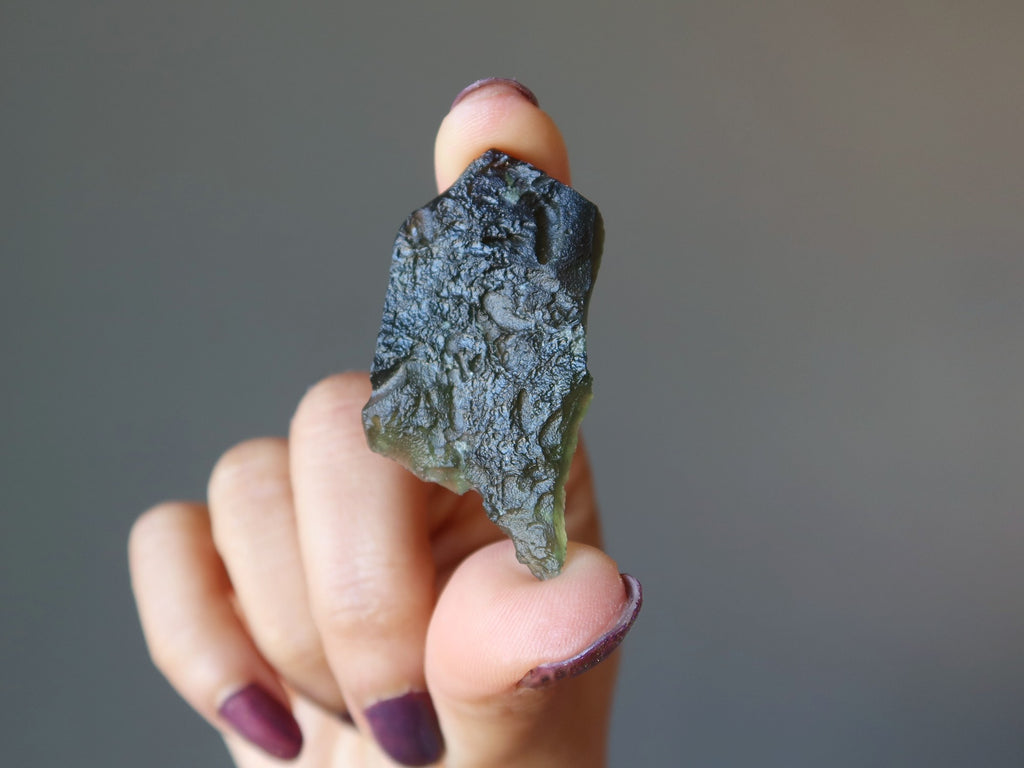 hand holding moldavite stone