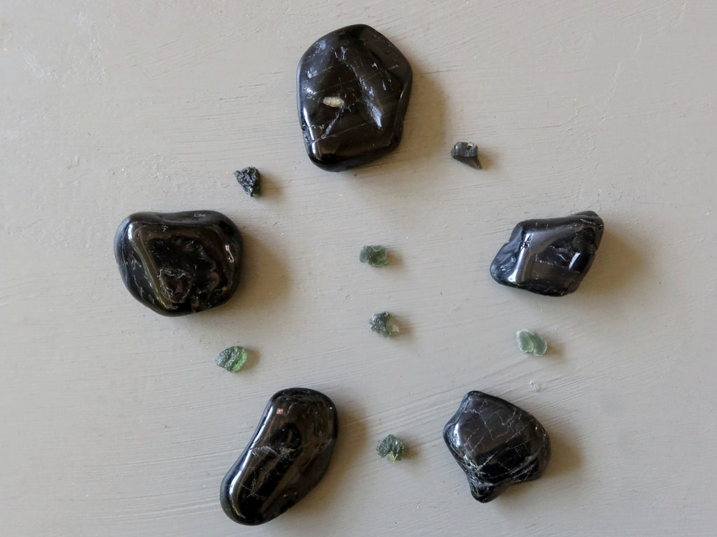 black tourmaline tumbled stones and raw moldavite