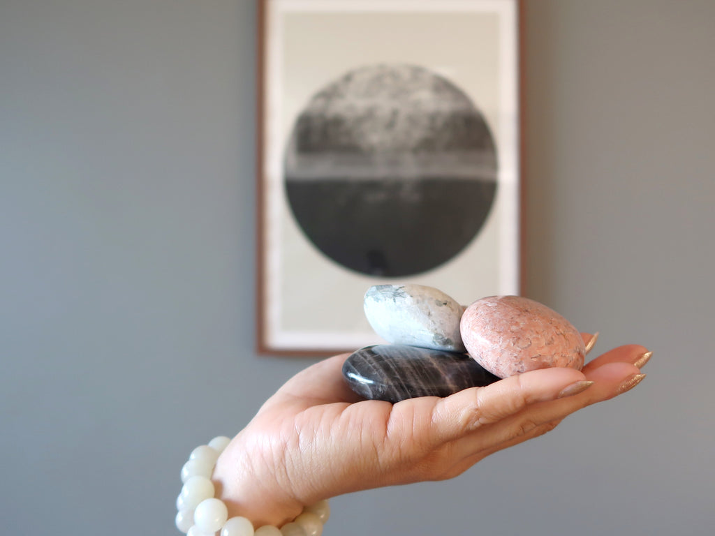 hand wearing and holding moonstone crystals