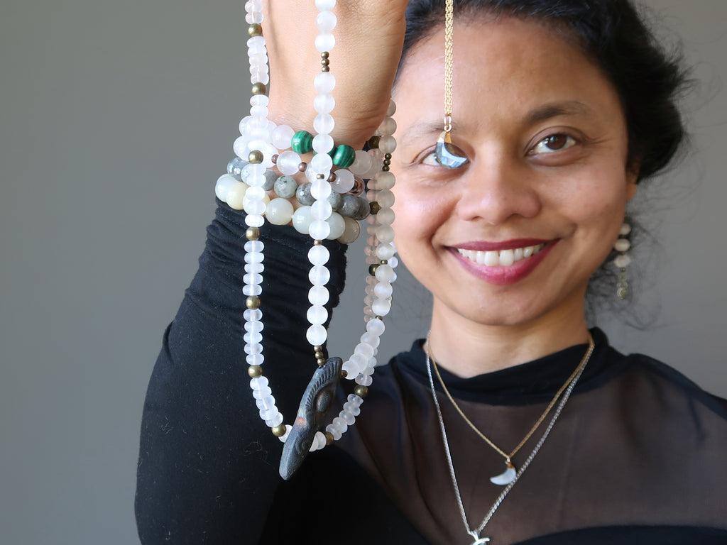 Sheila of Satin Crystals holding up moon inspired jewelry