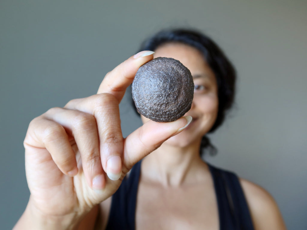 sheila of satin crystals holding a brown moqui stone ball