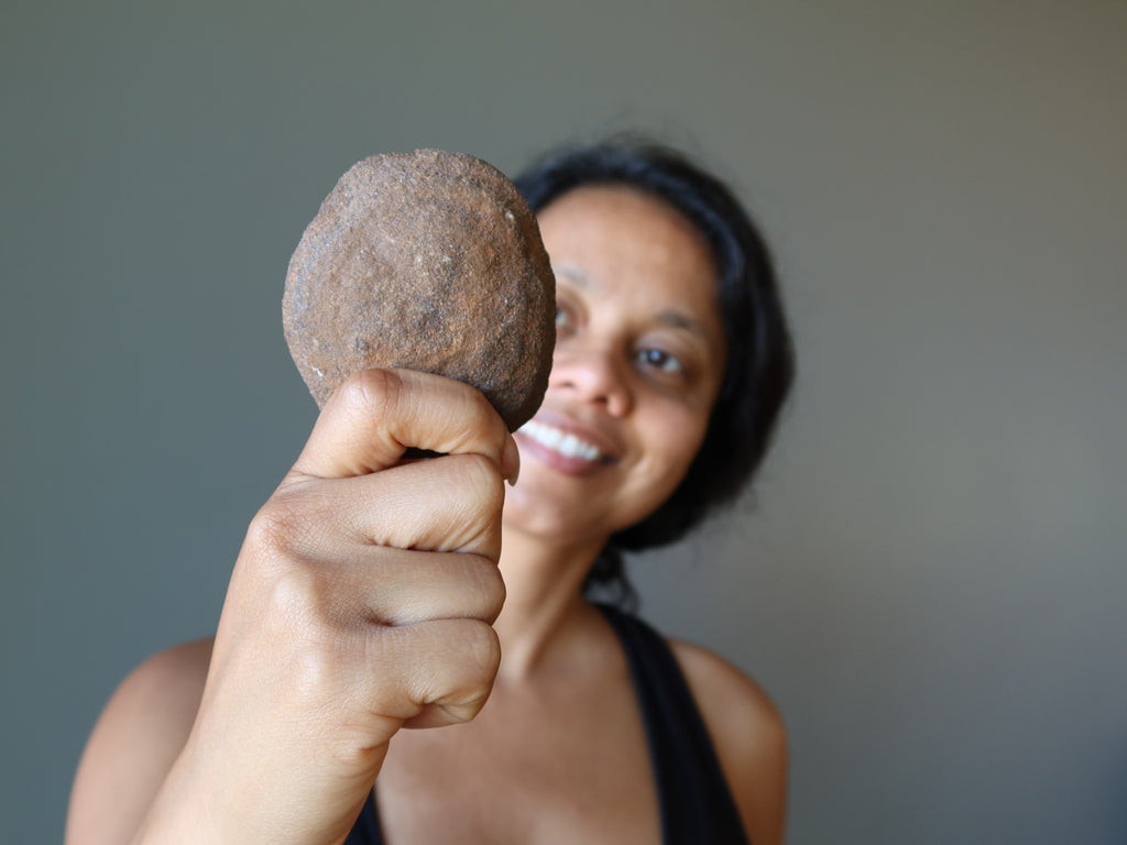 sheila of satin crystals holding a big brown moqui stone ball