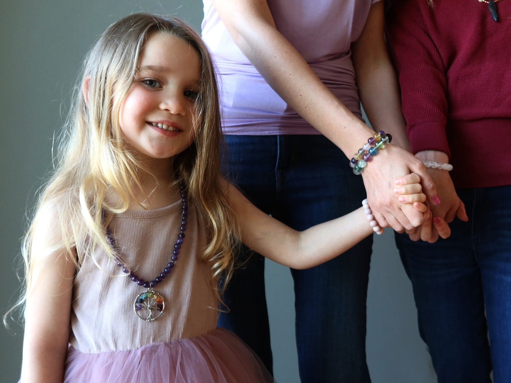 child holding mothers hand wearing crystals