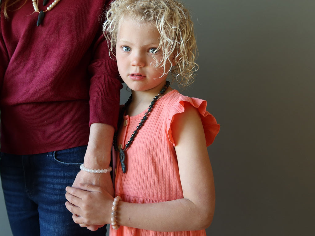 child holding mothers hand wearing crystals