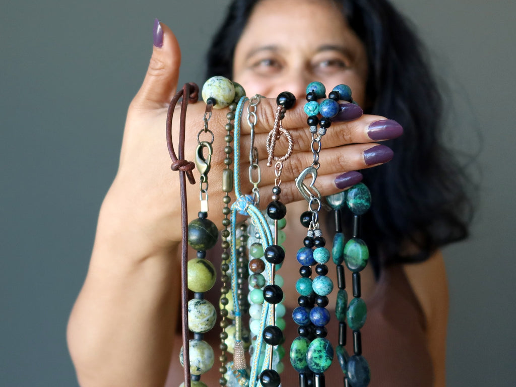 sheila of satin crystals holding different necklaces