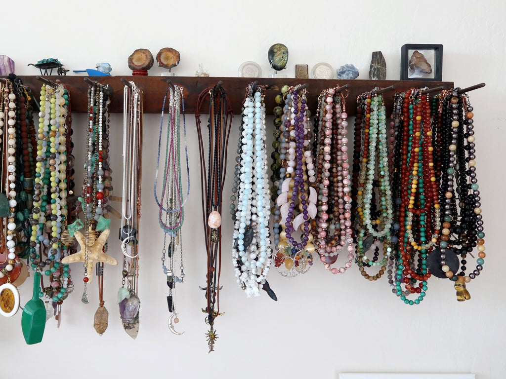 gemstone necklaces organized on a display rack