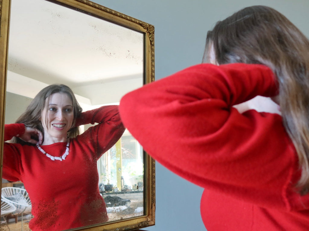 woman wearing a crystal necklace in a mirror