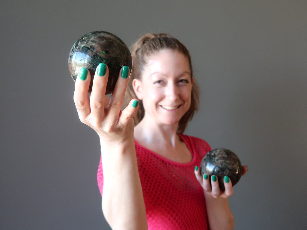 female model holding two chalcocite spheres