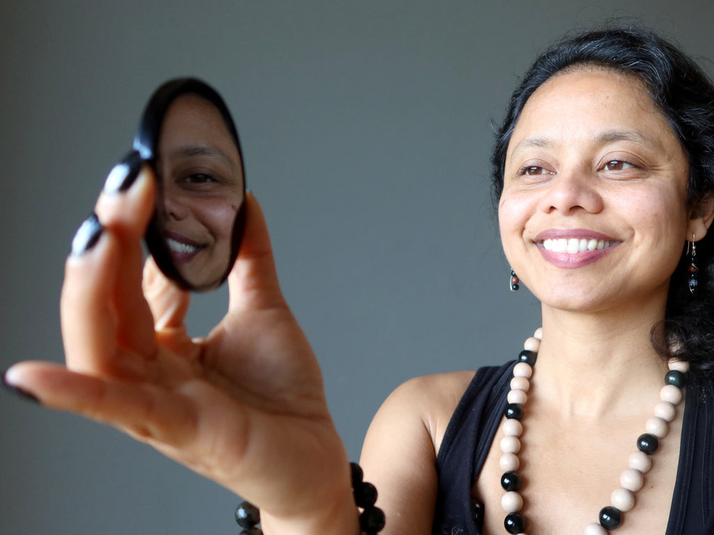 Sheila of Satin Crystals gazing at her reflection in an Obsidian mirror