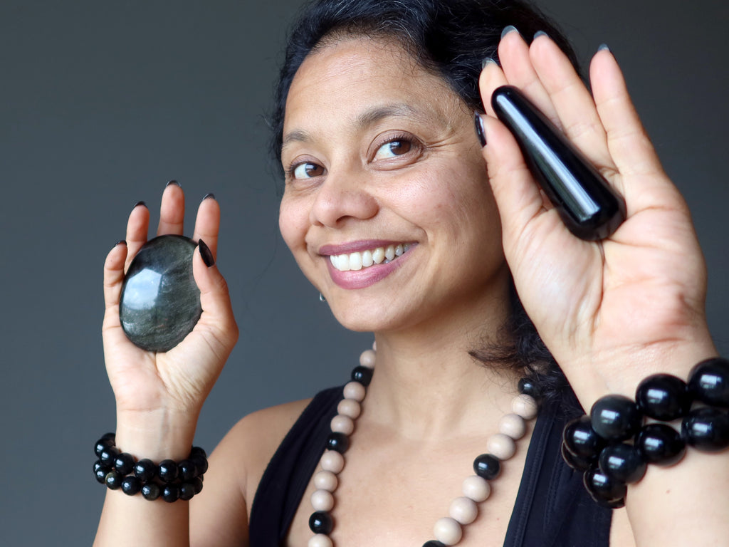 Sheila of Satin Crystals wearing Obsidian jewelry holding an Obsidian palm stone and massage wand