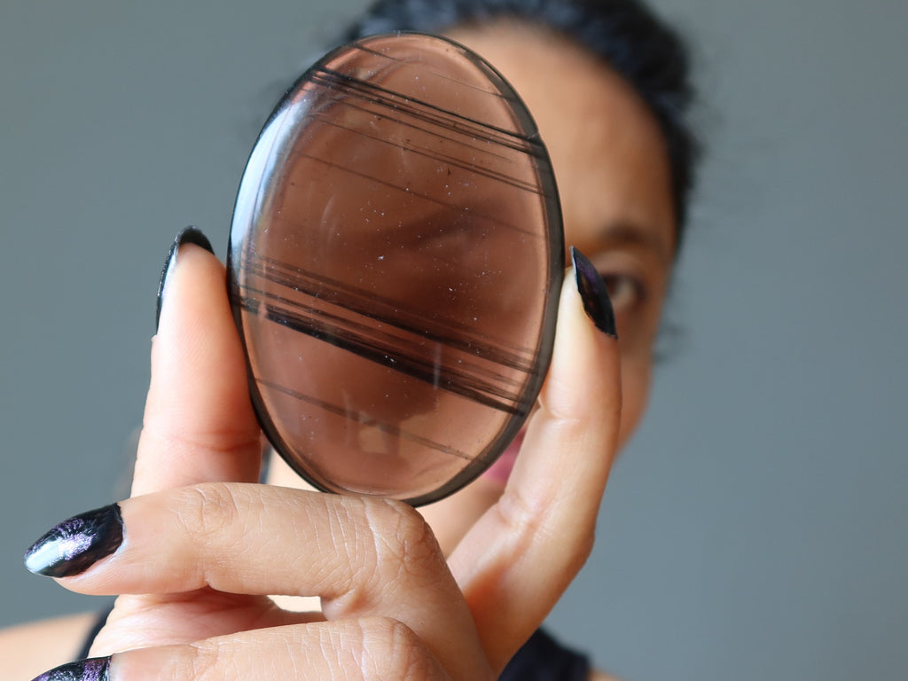 Sheila of Satin Crystals looking through a midnight lace obsidian stone