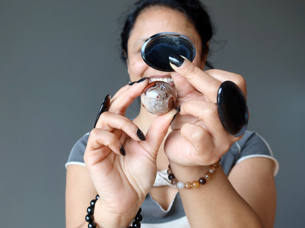 female holding and wearing onyx and sardonyx crystals