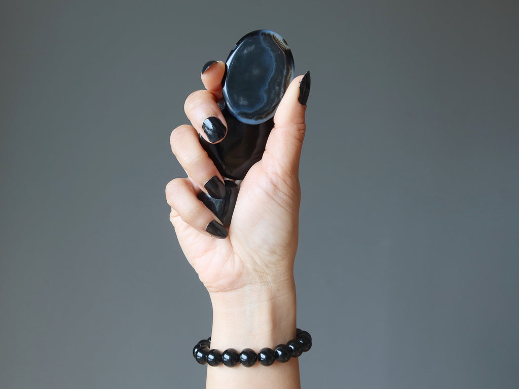 hand wearing and holding onyx stones