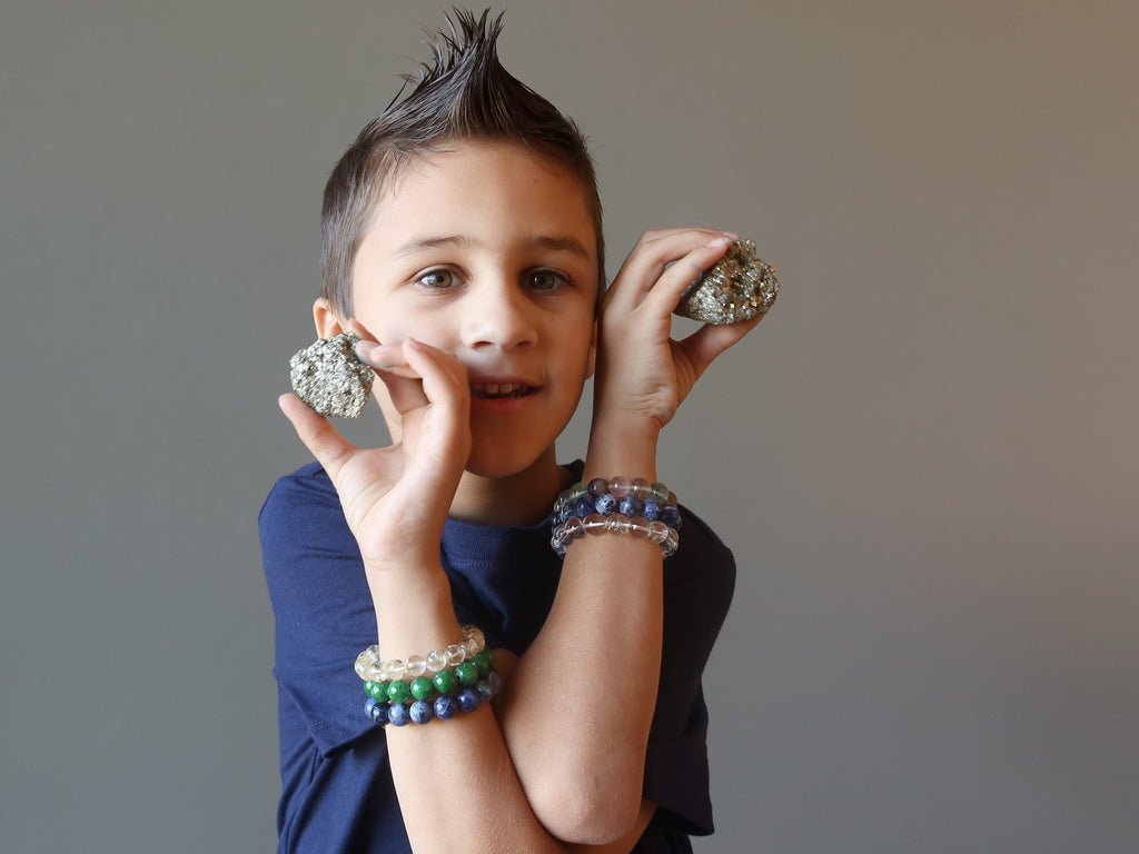 male child holding two pyrite clusters