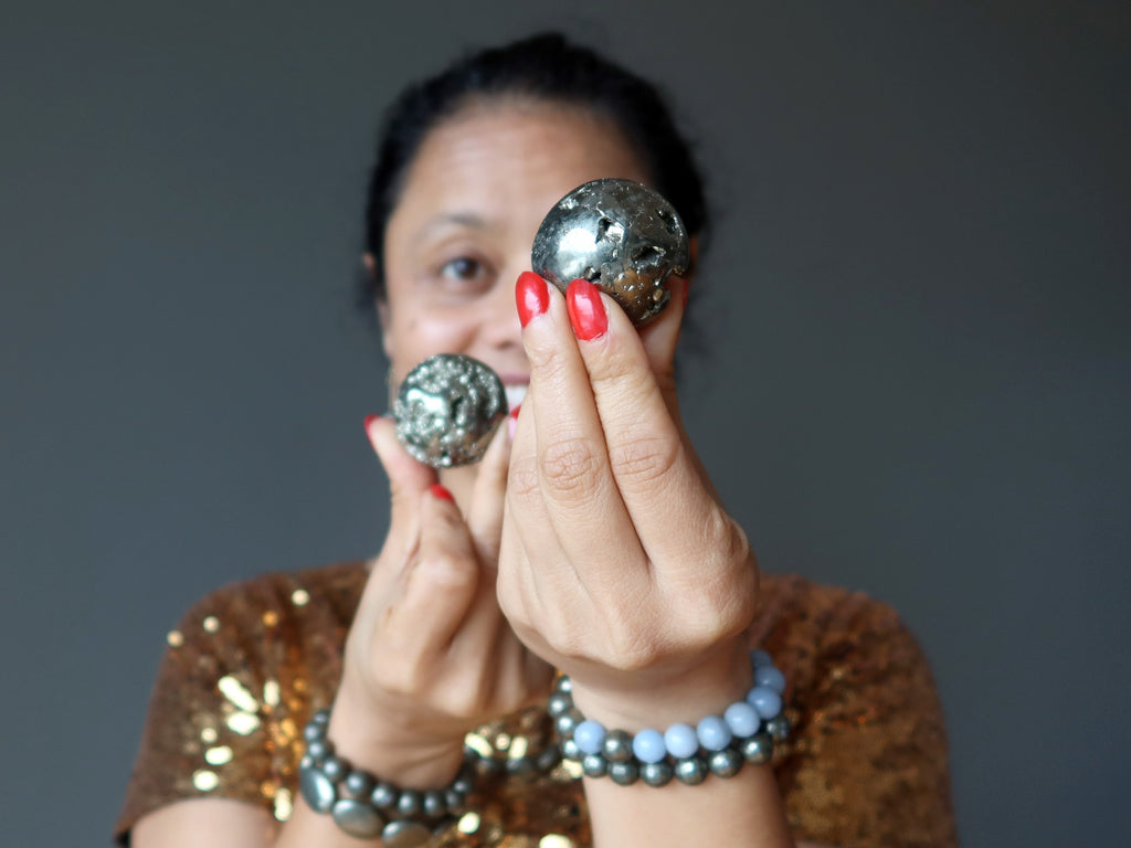 sheila of satin crystals holding two pyrite spheres