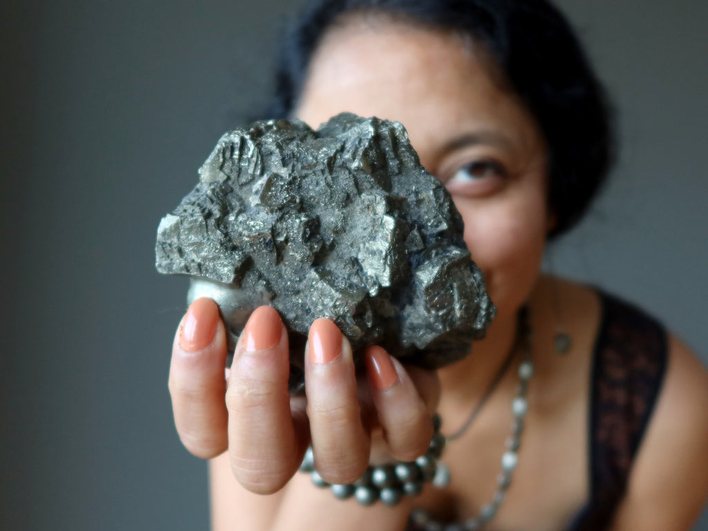 sheila of satin crystals holding out a large pyrite cluster