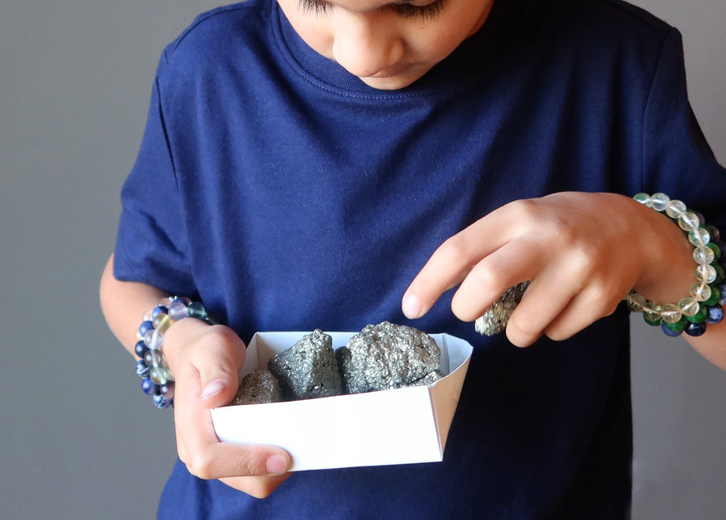 boy picking out pyrite clusters from a box