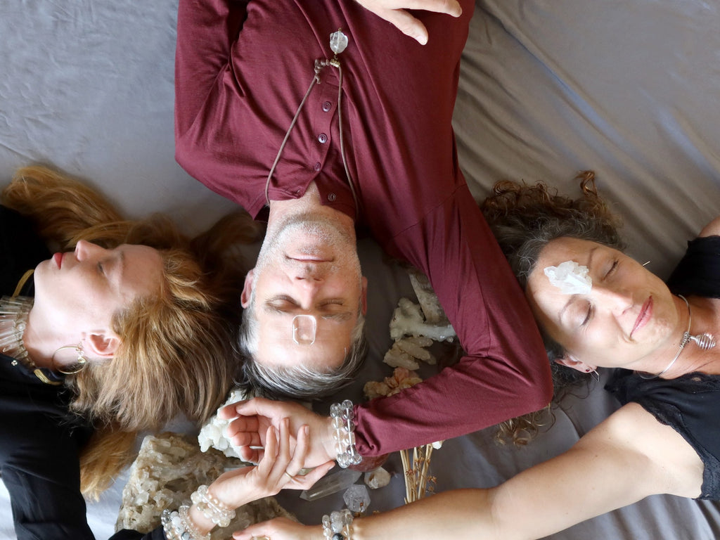 male and two females lying with quartz crystals