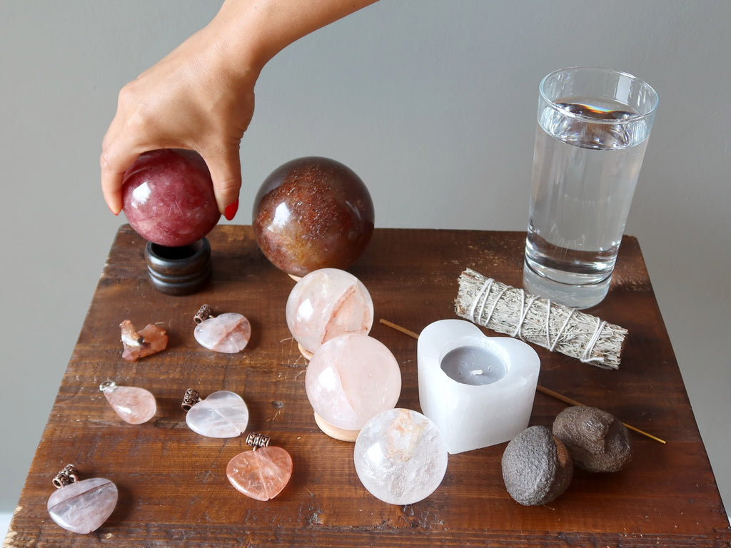 red quartz crystals, candle, sage, water, moqui for meditation