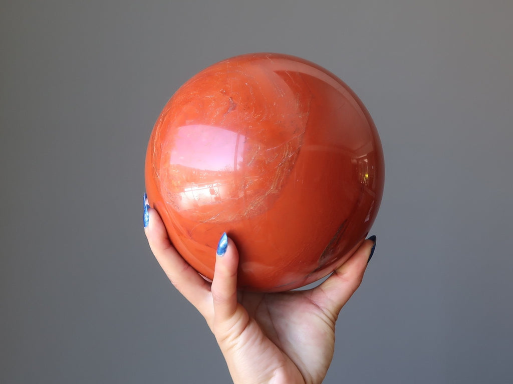 hand holding red jasper sphere