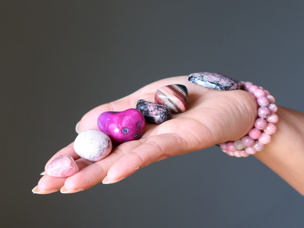 pink tumbled stones in hand wearing bracelets