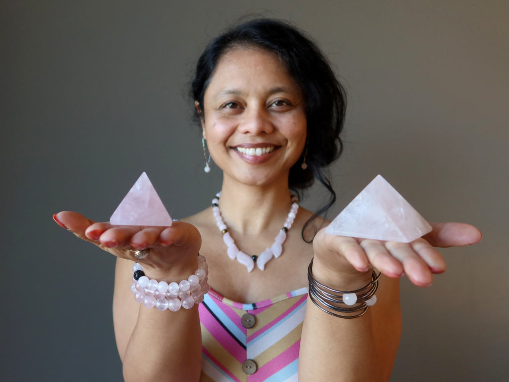 sheila of satin crystals holding two rose quartz pyramids in her palms