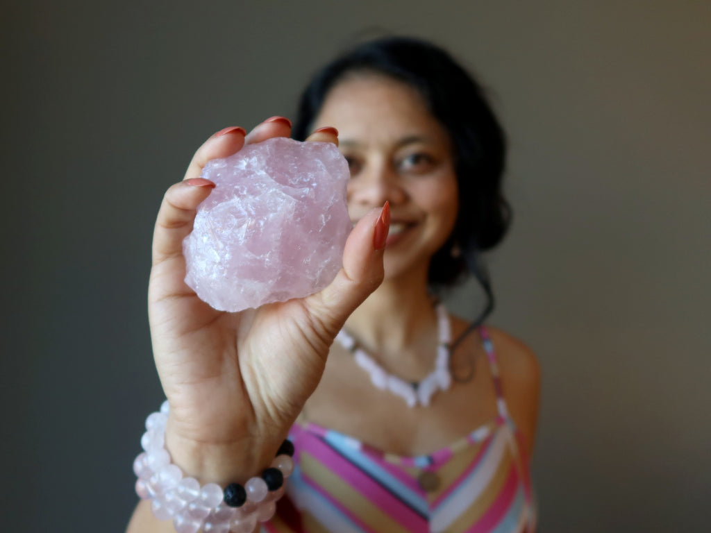 sheila of satin crystals holding a raw rose quartz crystal
