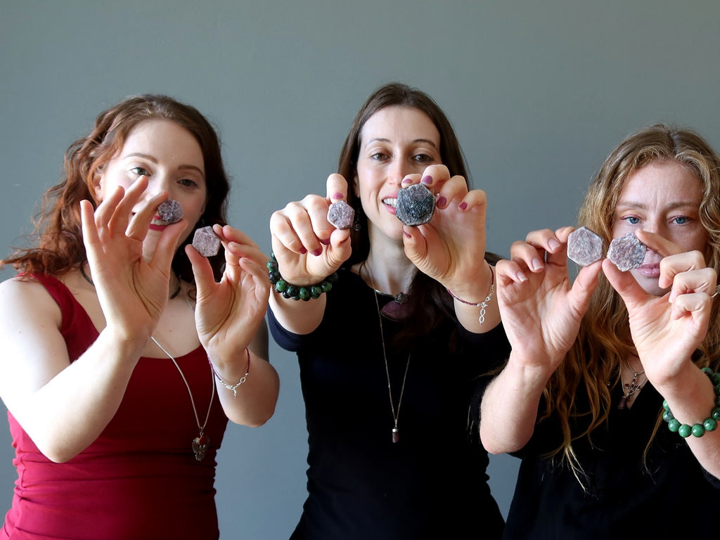 3 women holding ruby hexagon stones