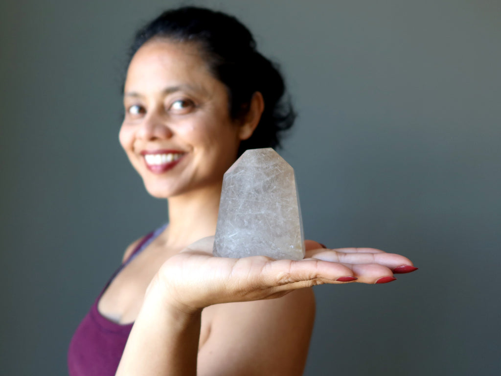 sheila of satin crystals holding a rutilated quartz tower