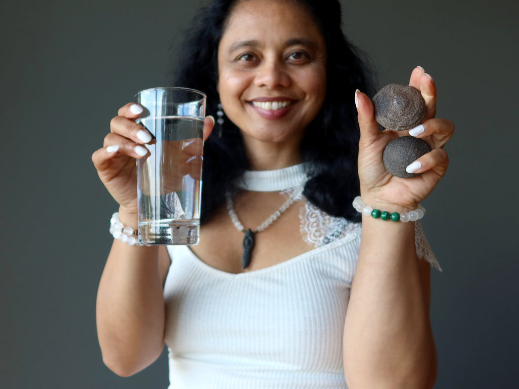sheila of satin crystals holding glass of water and moqui marble pair