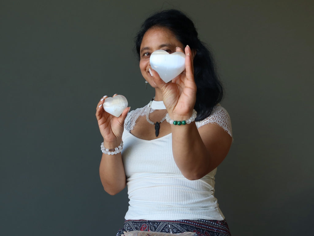 woman holding two selenite hearts