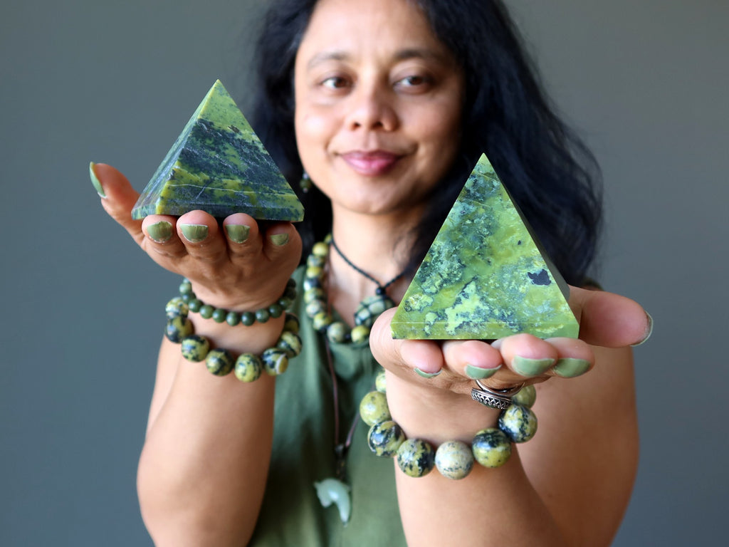 woman holding two serpentine pyramids