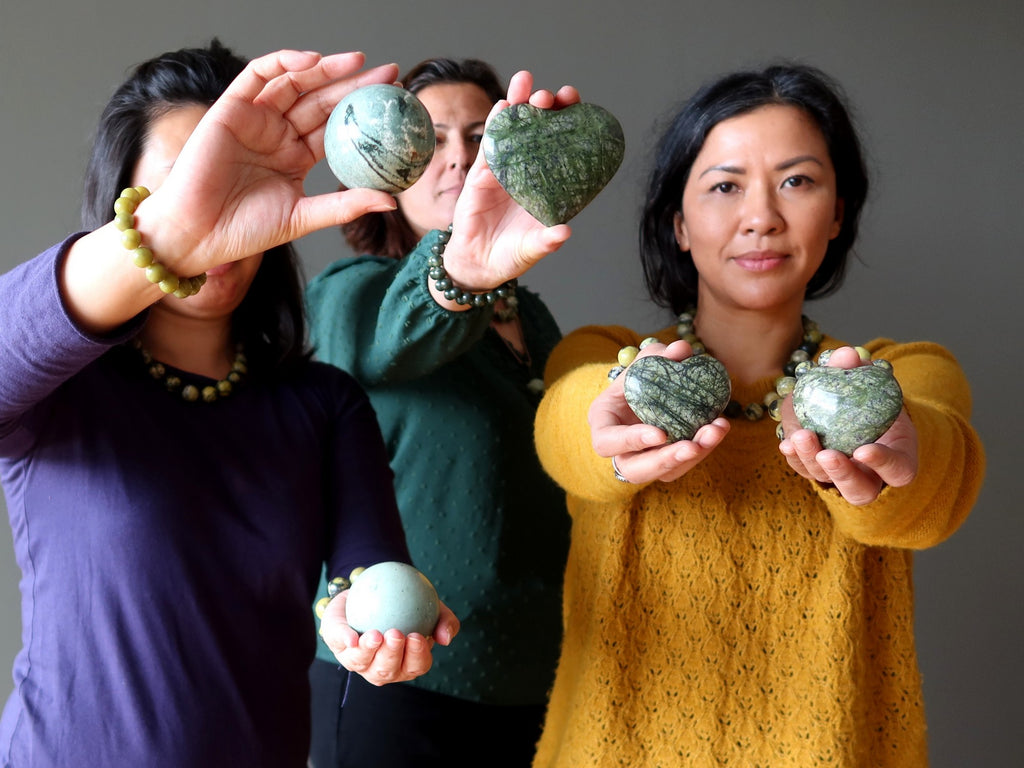 people holding serpentine hearts and spheres