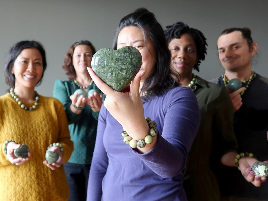 people holding serpentine hearts and spheres