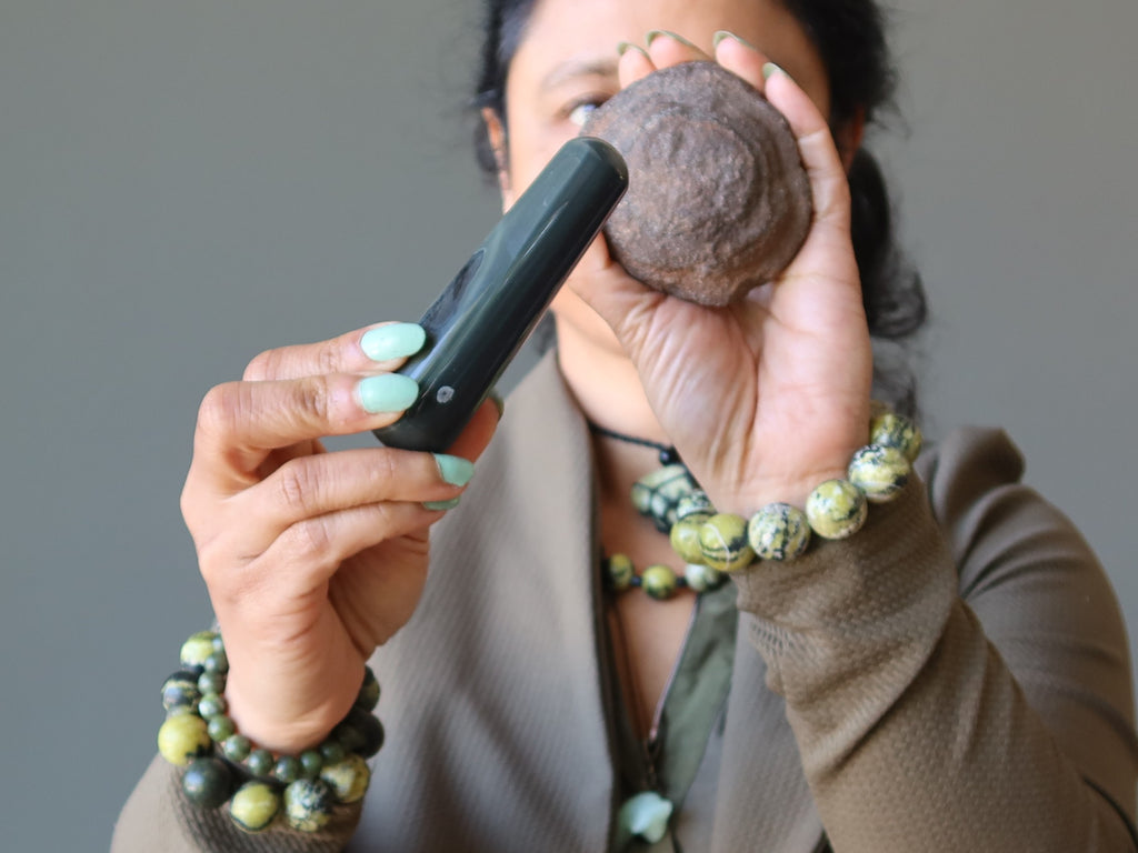 woman holding obsidian wand and moqui marble