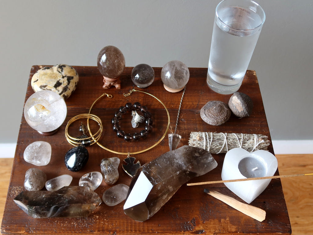 smoky quartz jewelry, stones, moqui marbles, water, candle for meditation