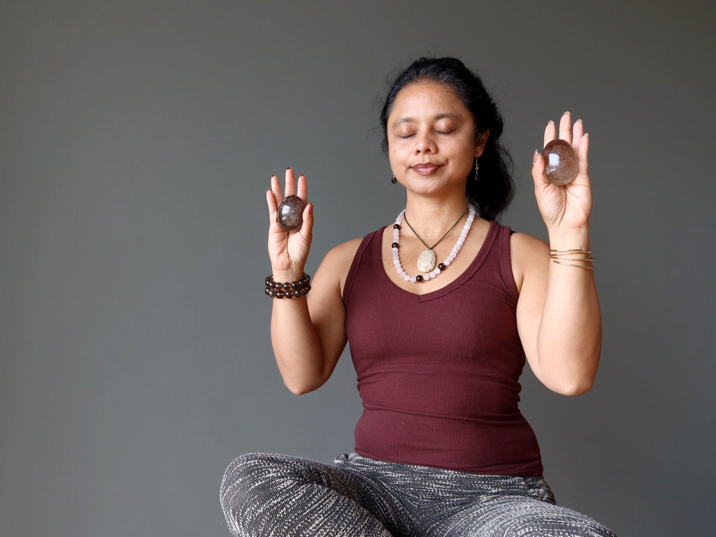 woman meditating with smoky quartz eggs