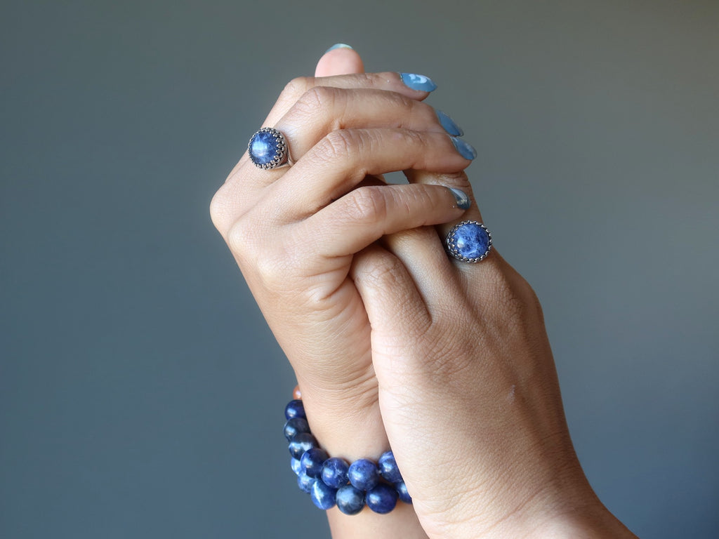 hands wearing sodalite rings and bracelets