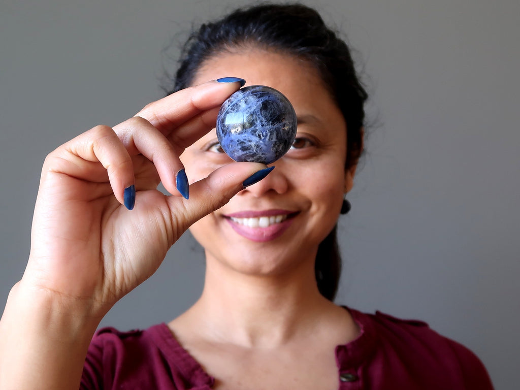 woman with sodalite sphere at third eye chakra