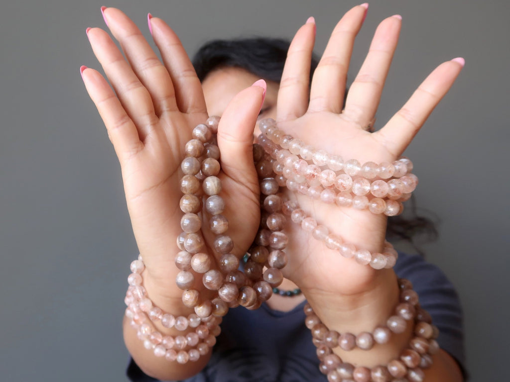 hands stacked with sunstone stretch bracelets