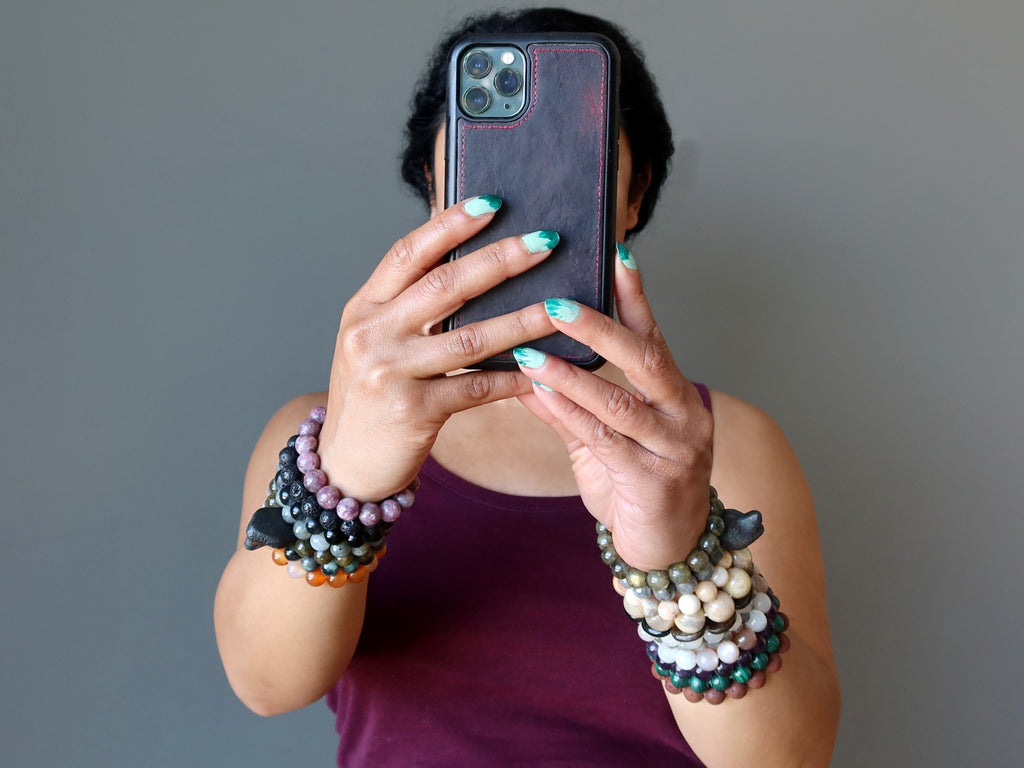 woman wearing a lot of bracelets looking at cell phone