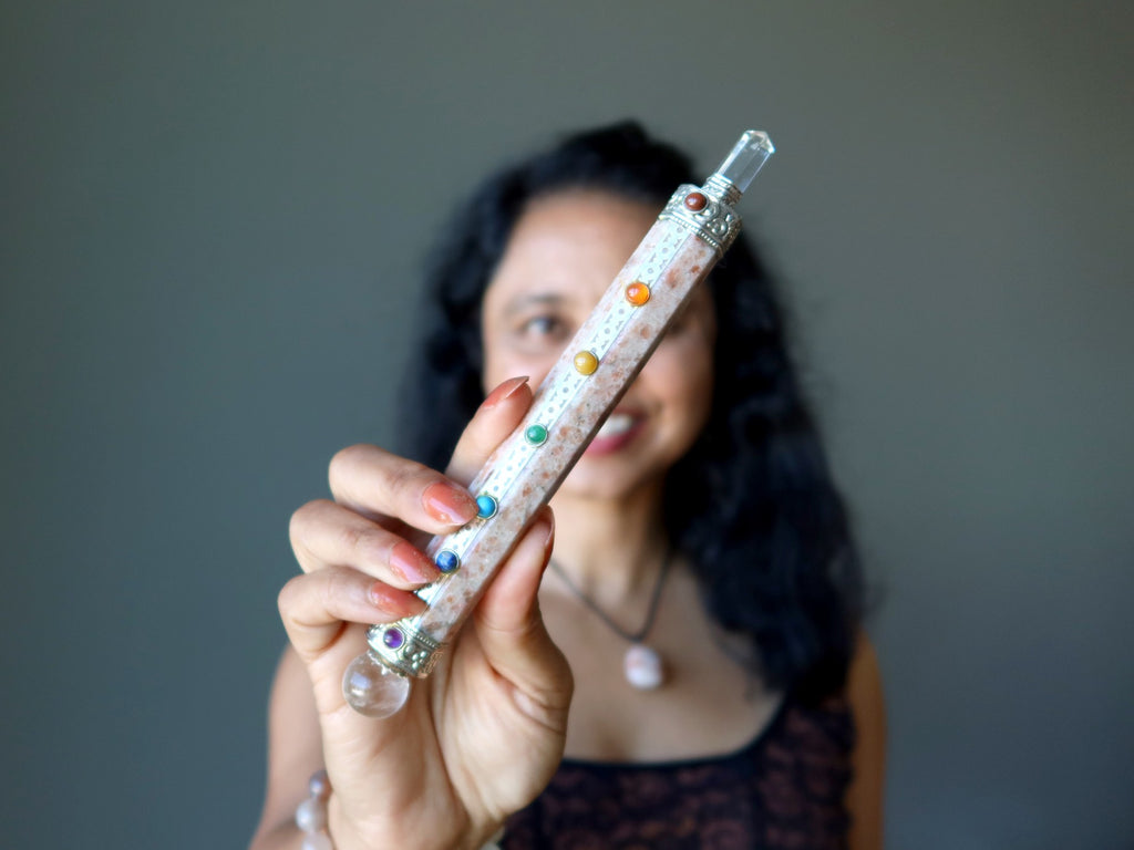 woman holding sunstone chakra wand