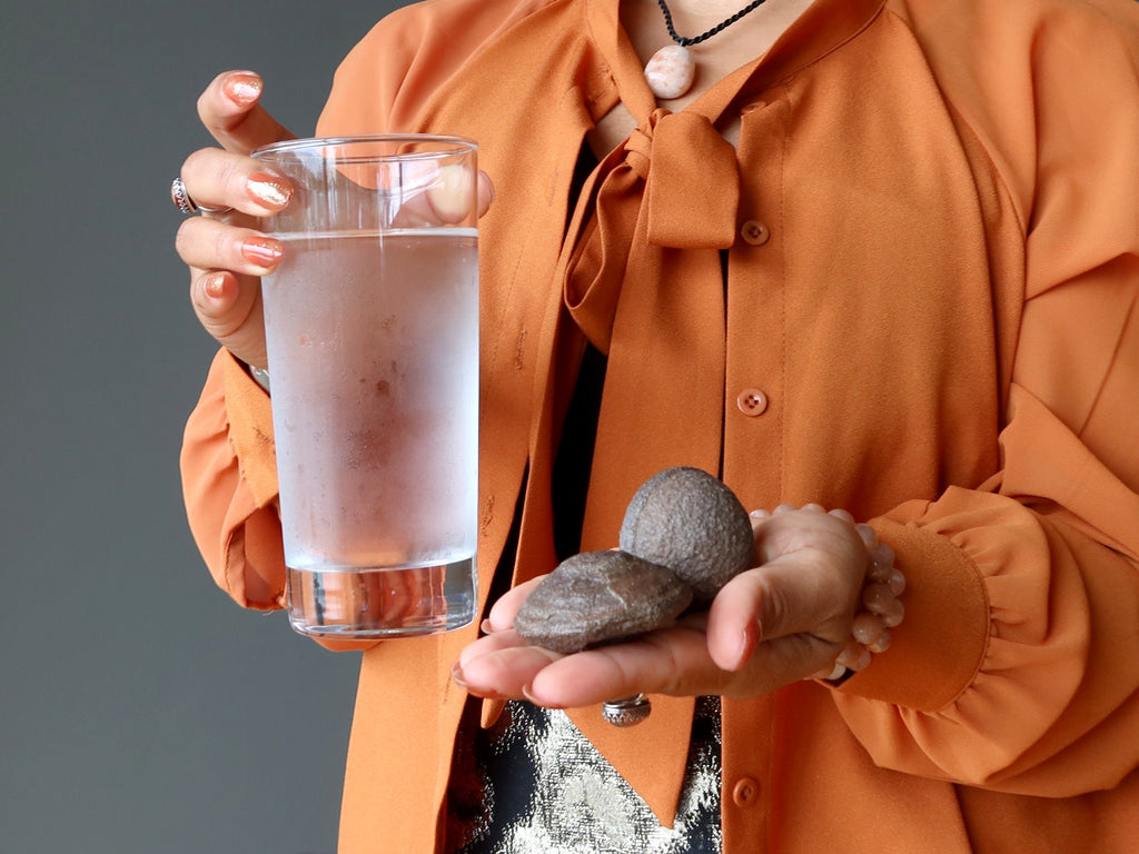 woman holding moqui stones and water