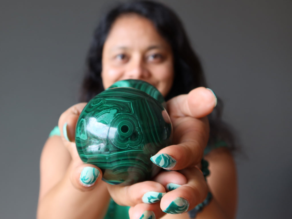 sheila of satin crystals holding green malachite spheres