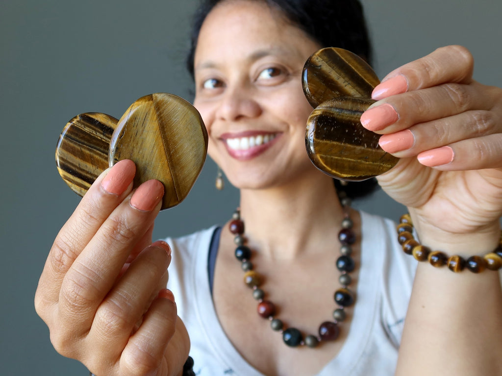 sheila of satin crystals holding four tigers eye palm slabs