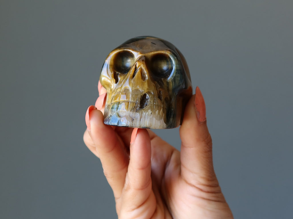 hand holding tigers eye skull