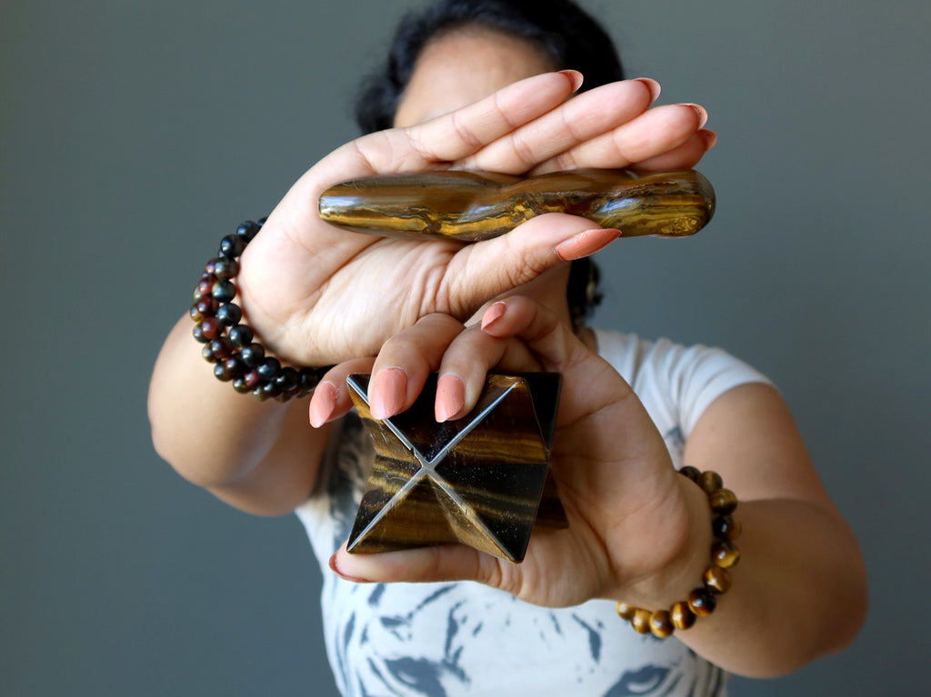 sheila of satin crystals holding out a tigers eye twist massage wand and merkaba