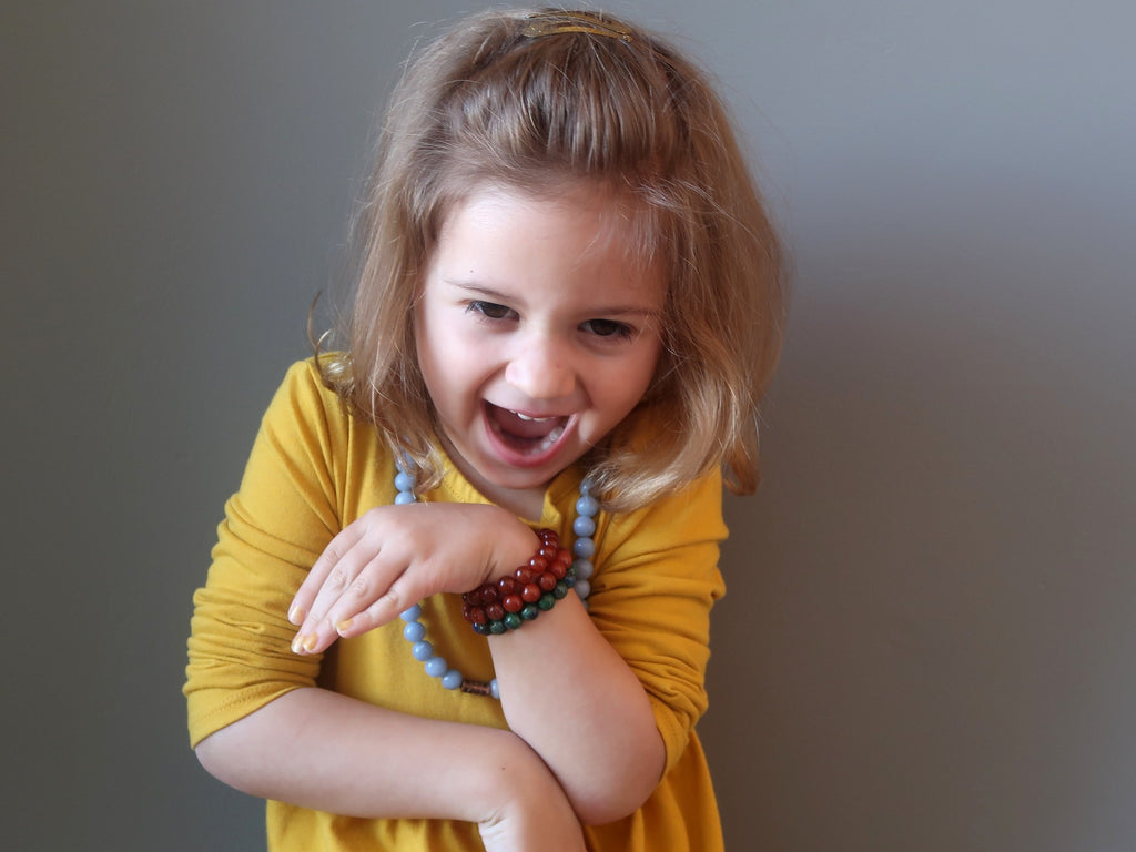 little girl laughing wearing crystal healing jewelry
