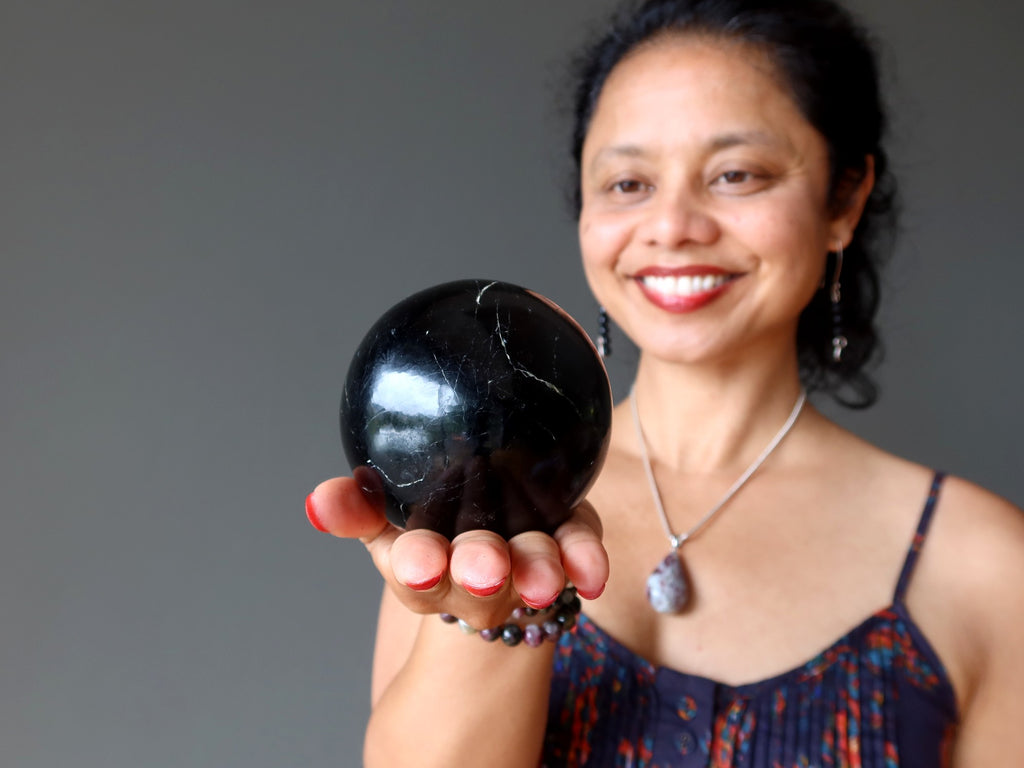 female gazing in black tourmaline sphere