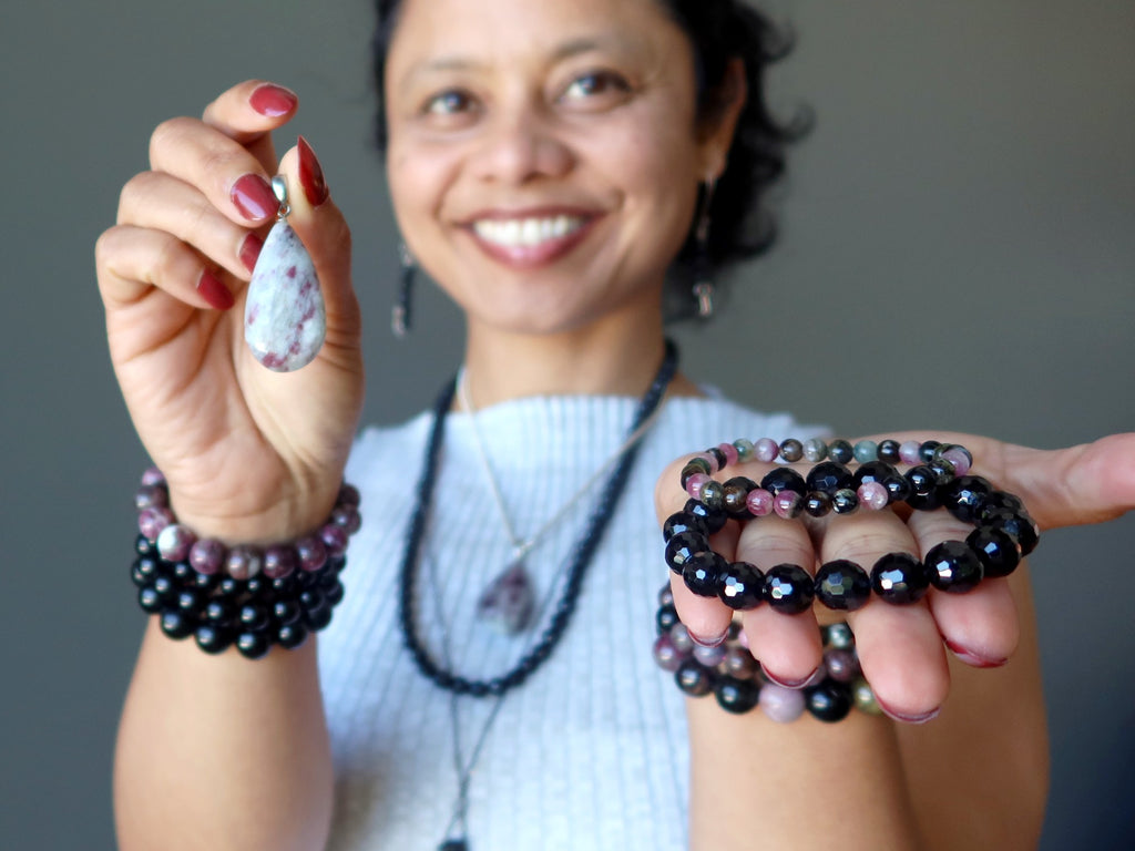 sheila of satin crystals wearing and holding tourmaline jewelry